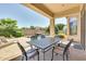 Covered back patio with a dining table, chairs, and a view of the pool, perfect for outdoor entertaining at 795 W Verbena Ln, Litchfield Park, AZ 85340