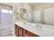 Well-lit bathroom featuring a double sink vanity, spacious mirror, and a shower-tub combo at 795 W Verbena Ln, Litchfield Park, AZ 85340