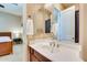 Cozy bathroom featuring a vanity with a sleek sink, framed mirror, and a glimpse into the adjacent bedroom at 795 W Verbena Ln, Litchfield Park, AZ 85340