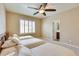 Bright bedroom with a ceiling fan, window, three beds with soft bedding, and ensuite bathroom at 795 W Verbena Ln, Litchfield Park, AZ 85340