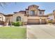 Stunning two-story home with a three-car garage, manicured lawn and a charming balcony with wrought iron details at 795 W Verbena Ln, Litchfield Park, AZ 85340