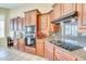 Kitchen featuring granite countertops, cherry cabinets, and stainless steel appliances at 795 W Verbena Ln, Litchfield Park, AZ 85340