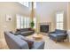 Sophisticated living room featuring high ceilings, large windows, and a cozy fireplace, creating a warm and inviting space at 795 W Verbena Ln, Litchfield Park, AZ 85340