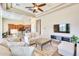 Spacious living room open to the kitchen, featuring tile flooring, comfortable seating, and a large screen television at 795 W Verbena Ln, Litchfield Park, AZ 85340