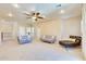 Spacious living room with plush carpeting, neutral tones, ceiling fan, and comfortable seating arrangement at 795 W Verbena Ln, Litchfield Park, AZ 85340