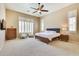 Main bedroom with ceiling fan, two white chairs, a blue and gray rug, and two windows at 795 W Verbena Ln, Litchfield Park, AZ 85340