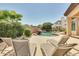 Relaxing pool area with a rock waterfall, lounge chairs, and lush tropical landscaping creating a private oasis at 795 W Verbena Ln, Litchfield Park, AZ 85340