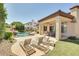 Resort-style pool with rock waterfall, lounge chairs, covered patio, and lush landscaping for ultimate relaxation at 795 W Verbena Ln, Litchfield Park, AZ 85340