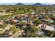 Aerial view of a neighborhood with houses and the neighboring golf course with mountain views in the background at 8255 E Vista De Valle --, Scottsdale, AZ 85255