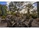 Outdoor seating area with comfortable chairs and a table, surrounded by mature trees and desert landscaping at 8255 E Vista De Valle --, Scottsdale, AZ 85255