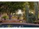 Scenic poolside view featuring lush landscaping, mature trees, and distant mountain views at 8255 E Vista De Valle --, Scottsdale, AZ 85255