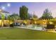 Inviting backyard with a pool, fire pit, lounge chairs, and well-maintained artificial turf at 831 E Tonto Pl, Chandler, AZ 85249