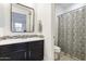 Bathroom featuring a modern vanity with unique backsplash, decorative mirror, and shower with patterned curtain at 831 E Tonto Pl, Chandler, AZ 85249