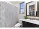 Bright bathroom featuring a modern vanity, decorative mirror, and a shower with patterned curtain at 831 E Tonto Pl, Chandler, AZ 85249