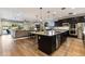 Bright open-concept kitchen with a large island, stainless appliances, and hardwood floors overlooking living area at 831 E Tonto Pl, Chandler, AZ 85249