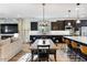 Open-concept kitchen and dining area with stainless steel appliances, kitchen island, and dark cabinetry at 831 E Tonto Pl, Chandler, AZ 85249