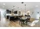 Modern kitchen with island, stainless steel appliances, and dark cabinets connected to an open dining area at 831 E Tonto Pl, Chandler, AZ 85249
