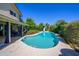 Spacious backyard featuring a sparkling pool, covered patio, and lush landscaping, creating an ideal outdoor retreat at 8419 E Stella Ln, Scottsdale, AZ 85250