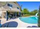 Inviting backyard featuring a sparkling pool, covered patio with comfortable seating, and meticulously maintained landscaping at 8419 E Stella Ln, Scottsdale, AZ 85250