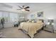 Bright bedroom with plush carpet, ceiling fan, and shuttered windows at 8419 E Stella Ln, Scottsdale, AZ 85250
