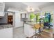 Bright kitchen featuring white cabinets, granite countertops, stainless steel appliances, breakfast bar, and pool view at 8419 E Stella Ln, Scottsdale, AZ 85250