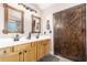 Well-appointed bathroom featuring a double vanity, wooden cabinets, and decorative mirrors at 8755 E Portobello Ave, Mesa, AZ 85212
