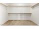 Empty walk-in closet with two rows of wooden shelves and carpeted floors at 8755 E Portobello Ave, Mesa, AZ 85212