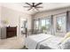 Bright, airy bedroom with a view into the bathroom, a ceiling fan, and carpeted floor at 8755 E Portobello Ave, Mesa, AZ 85212