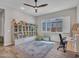 Bright bedroom featuring a large bookcase, a cozy rug, and a window with plantation shutters at 9253 W Sands Dr, Peoria, AZ 85383