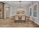 Elegant dining room with a rustic wooden table, modern lighting, and stylish white-painted wainscotting at 9253 W Sands Dr, Peoria, AZ 85383