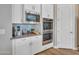 Bright kitchen boasts stainless steel appliances, blue glass tile backsplash, and white cabinets at 9253 W Sands Dr, Peoria, AZ 85383