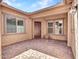 Covered patio featuring neutral stucco walls, brick pavers, and ample natural light, perfect for outdoor relaxation at 9253 W Sands Dr, Peoria, AZ 85383