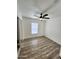 Bright bedroom featuring wood-look floors, a ceiling fan, and sliding closet doors at 9601 N 35Th Dr, Phoenix, AZ 85051