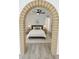 Comfortable bedroom with wood-look flooring framed by a brick archway at 9601 N 35Th Dr, Phoenix, AZ 85051