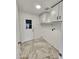 Bright laundry area boasts marble-patterned tile flooring, white cabinets, and utility sink hookups at 9601 N 35Th Dr, Phoenix, AZ 85051