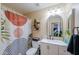 Stylish bathroom with a modern vanity, decorative mirror, and shower with patterned curtain at 9713 E El Paso St, Mesa, AZ 85207