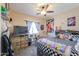 Cozy bedroom featuring a checkered bedspread, ceiling fan, and personal touches at 9713 E El Paso St, Mesa, AZ 85207