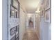 Well-lit hallway featuring neutral walls, decorative artwork, and access to various rooms at 9713 E El Paso St, Mesa, AZ 85207