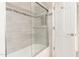 Tiled tub and shower combination with glass doors and white door entrance at 9809 W Behrend Dr, Peoria, AZ 85382