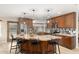 Spacious kitchen with granite island, custom cabinetry, stainless steel appliances, and stylish pendant lighting at 9809 W Behrend Dr, Peoria, AZ 85382