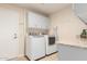 Bright laundry room with modern washer and dryer, storage cabinets, and granite countertop at 9809 W Behrend Dr, Peoria, AZ 85382