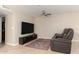 Cozy living room features tile floors, a ceiling fan, and a flat screen television at 9809 W Behrend Dr, Peoria, AZ 85382