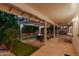 Covered patio featuring a fire pit, comfortable seating, an outdoor cooking area, and views of the lush greenery at 9809 W Behrend Dr, Peoria, AZ 85382