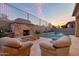 Cozy outdoor area featuring a stone fireplace and comfortable seating near the pool at 9847 E Preserve Way, Scottsdale, AZ 85262