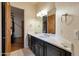 Bathroom with double sinks and wood door leading to bedroom at 9847 E Preserve Way, Scottsdale, AZ 85262