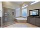 Bathroom with a glass enclosed shower, tub, and neutral design elements at 9847 E Preserve Way, Scottsdale, AZ 85262