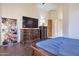 Bedroom featuring a stylish dresser, TV, and wood flooring at 9847 E Preserve Way, Scottsdale, AZ 85262