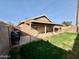 Spacious backyard with a covered patio, lawn, and block fence, perfect for outdoor enjoyment at 10705 W Montecito Ave, Phoenix, AZ 85037