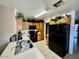 Functional kitchen with black appliances, wood cabinets, and a double basin sink at 10705 W Montecito Ave, Phoenix, AZ 85037