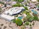 Expansive estate with a unique architecture, pool and tennis courts nestled in lush landscaping and desert surroundings at 11717 E Estrella Ave, Scottsdale, AZ 85259